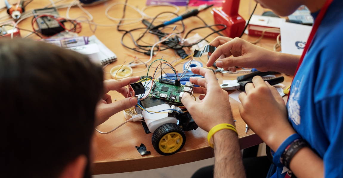 Two students assemble a handmade RC car